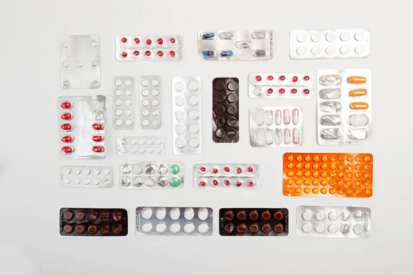 薬の錠剤と白いれたら上に水ぶくれの丸薬のヒープ — ストック写真