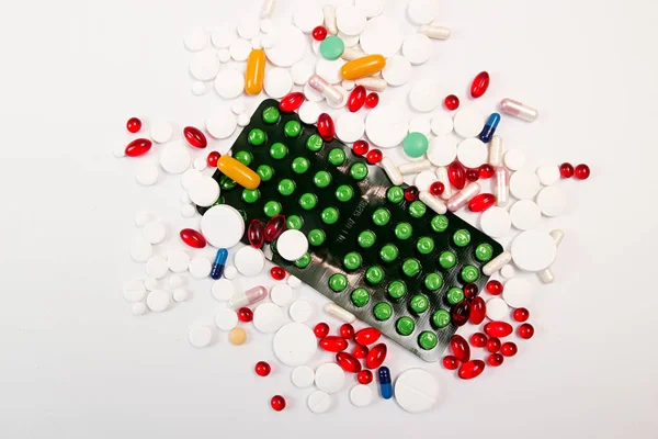 Montón de tabletas y pastillas sobre fondo blanco . — Foto de Stock