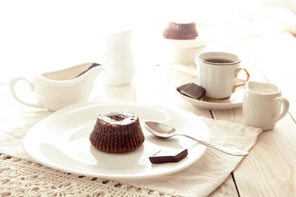 Choklad franska kaka mi-cuit på vit platta över på vitt bord — Stockfoto
