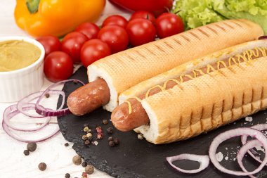 Sosisli sandviç sebze ile siyah arduvaz kaplamak üzerinde