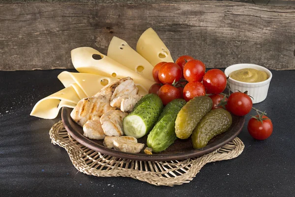 Teller mit gegrilltem Chiken, Käse, Kirschtomaten und Gurken — Stockfoto