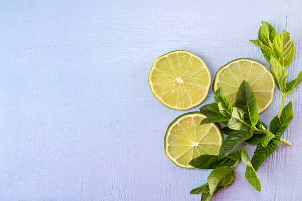 Flat lay still life with mint and lime on blue background. Pop a — Stock Photo, Image