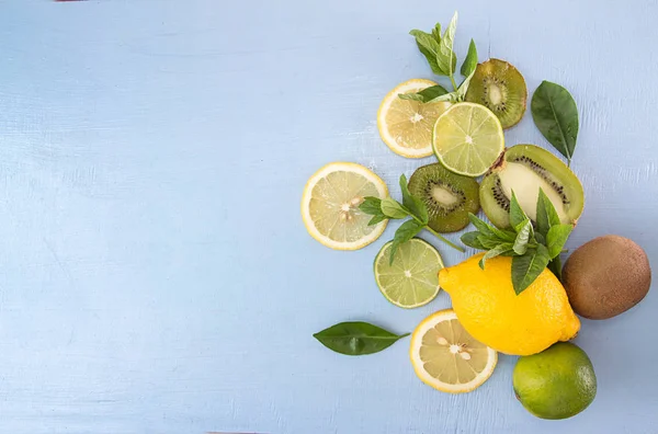 Flat lay still life with mint, kiwi, lemon and lime on blue back — Stock Photo, Image