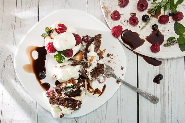 จานที่มีเค้กช็อคโกแลตตกแต่งด้วยราสเบอร์รี่ ครีมเช็ด — ภาพถ่ายสต็อก