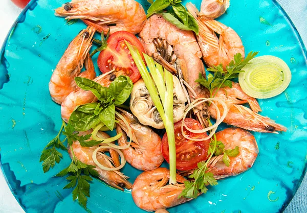 Bbq grilled shrimps on blue plate serving with cherry tomato, parsley, basil, leek and baked garlic. Barbecue seefood concept. Healthy diet food. Top view — Stock Photo, Image