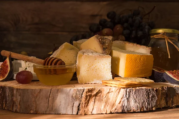 Composición de alimentos con bloques de queso mohoso, ciruelas en escabeche, cariño —  Fotos de Stock