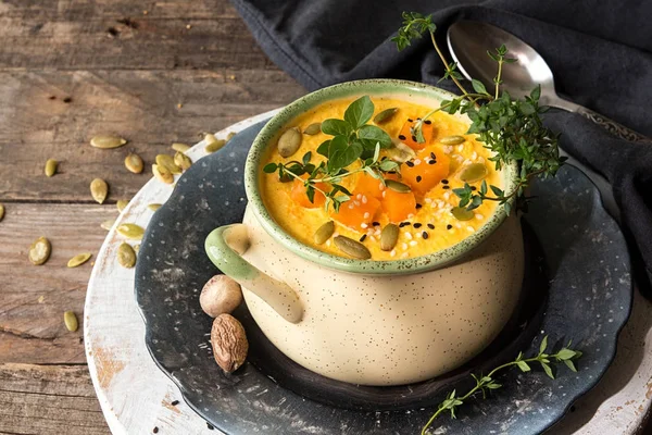 Zuppa di zucca in ciotola beige con pezzi di zucca, semi e lei — Foto Stock