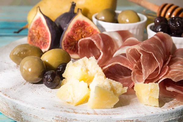 Piatto di formaggio con fette di prosciutto, pezzi di formaggio, olive — Foto Stock