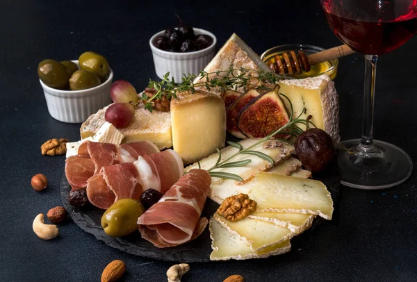 Bicchiere di vino rosso e piatto di formaggio con pezzi di formaggio ammuffito, pro — Foto Stock