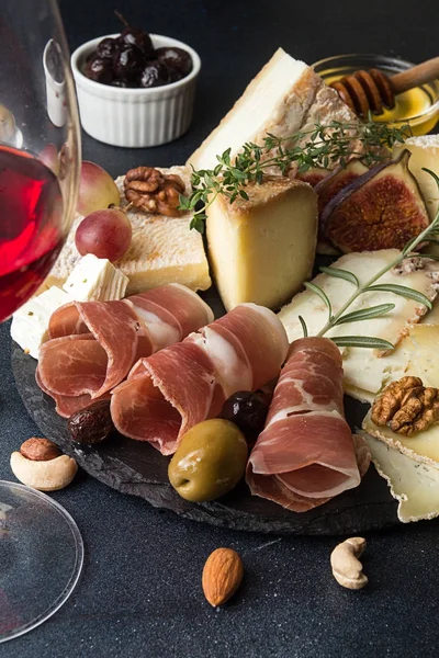 Bicchiere di vino rosso e piatto di formaggio con pezzi di formaggio ammuffito, pro — Foto Stock