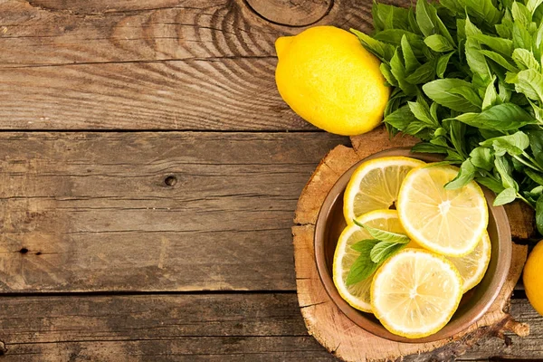 Bundl of mint and slices of lemon on old wooden background. Copy — Stock Photo, Image