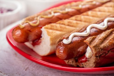 Kırmızı tabakta beyaz arka planda sosisli sandviç. Fast food, American T