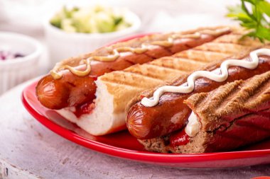 Kırmızı tabakta beyaz arka planda sosisli sandviç. Fast food, American T