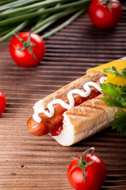 Sosisli sandviç, arka planda vişneli domates. Fast food, ameri.