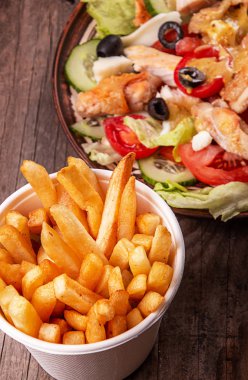 Kızarmış patates cipsi, beyaz kasede çıtır patates ve tavuk sebzesi.