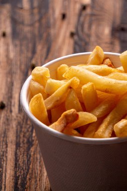 Beyaz kağıt kase patates kızartması Tahta masada patates kızartması