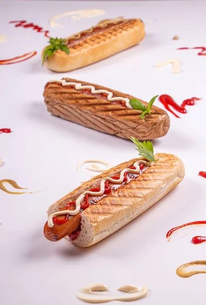 Cachorros-quentes em fundo branco.. Ketchup, maionese, mostarda e — Fotografia de Stock