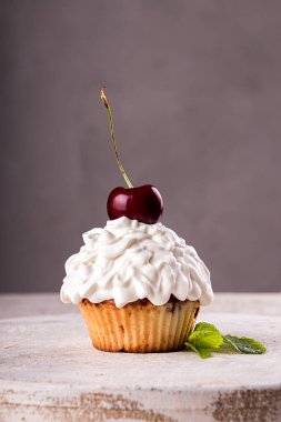 Gri arka planda çilekle süslenmiş kremalı kek.. 