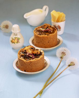 Mavi arka planda mantarlı tarlar, karamelize edilmiş kırmızı soğan ve peynir.