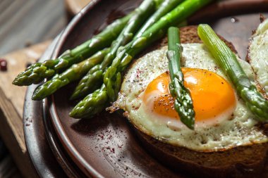 Kuşkonmaz ve kızarmış yumurta ile lezzetli tost ekmekli sandviç..