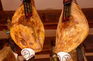 TOLEDE, İspanya - 16 Temmuz 2018. Jamon Iberico (kurutulmuş İspanyol jambonu) özel bir mağazada sergilenmektedir. Pazarda satılık fiyat etiketli bacaklar.