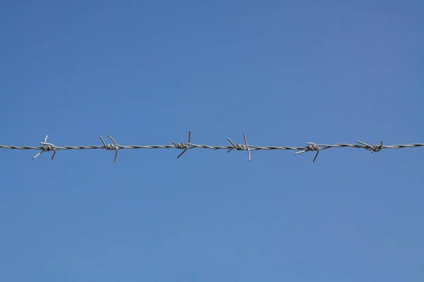 Recinzione spinato con cielo blu — Foto Stock