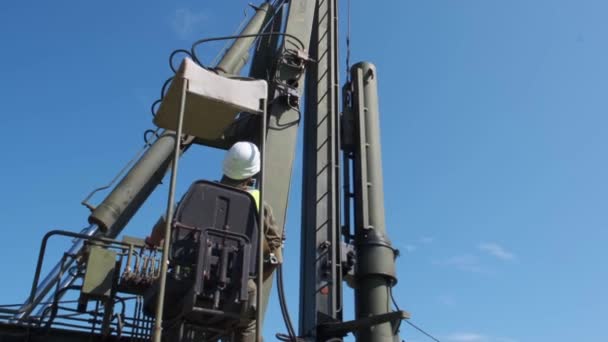 La macchina spinge una struttura di legno mucchio nel terreno. Costruzione della fondazione di strutture in cemento armato . — Video Stock