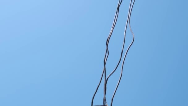 Le crochet d'une grue de construction suspendu à un boom sur un ciel clair 