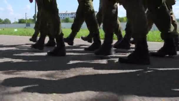 Kadeti, vojáci pochodující ve skupině po mokré cestě v černých botách a maskovacích uniformách. Armáda provádí bojovou misi. — Stock video