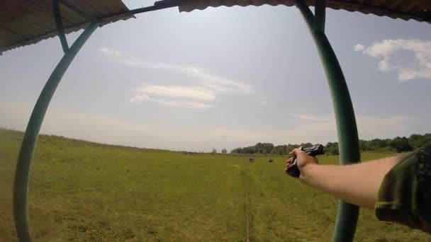 En militär skjuter mål på ett fält med en svart Pov stridspistol. För in ammunition med vänster hand — Stockvideo