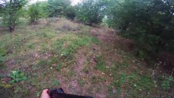 Pov militairen lopen door het bos met een geweer. Schieten en herladen van wapens — Stockvideo