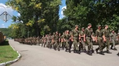 Rusya, Maykop - 2 Ağustos 2019. Öğrenciler, askerler yol boyunca siyah botlar ve kamuflaj üniformalarıyla yürüyen bir grup. Ordu bir savaş görevi yürütüyor.