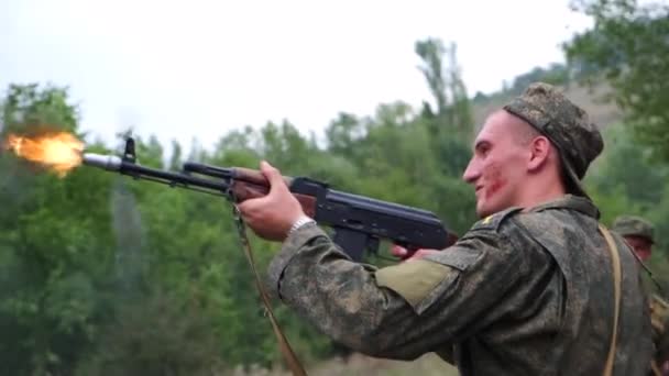 俄罗斯 梅科普 2019年8月2日 一个身穿军装 满脸血淋淋的士兵 站在那里用Ak 74型军用武器向敌人射击 在森林里与敌方学员战斗 — 图库视频影像