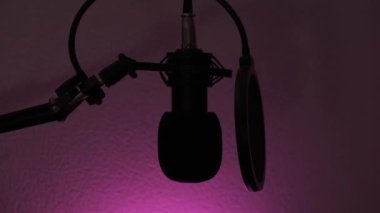Müzik ya da ses kaydı için profesyonel mikrofon. Lambanın ışığı, arka planda ışığa göre değişir. Gölgelerle oynanan bir oyun. Renk mavi, kırmızı, yeşil olarak değişir. Polis teması