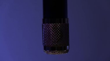 Müzik ya da ses kaydı için profesyonel mikrofon. Lamba lambası, krom bir mikrofonda, ışık arka planında yanıp sönüyor. Renk mavi, kırmızı, yeşil olarak değişir. Polis teması