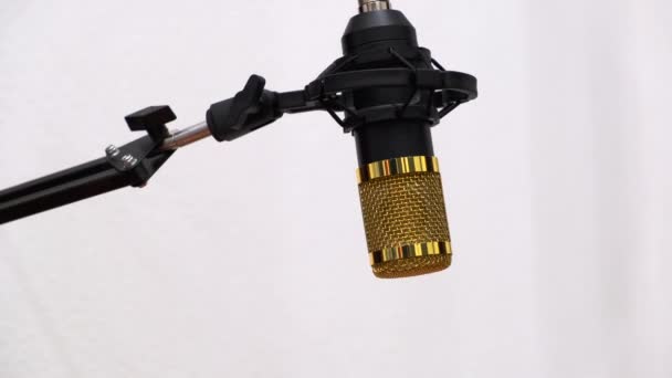 音楽や声を録音するためのプロのマイクの出現 白い背景に防風スタンドとケーブルを備えたクロムマイクの実用的なチューニング 防風除去 — ストック動画