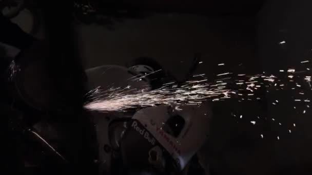 Moskau - 9. März. Der Mensch arbeitet mit einer Kreissäge. Funkenflug aus heißem Metall. Der Mann arbeitet mit einem Sportmotorrad in der Garage. Arbeit Motorsägen Metall Handwerkzeug — Stockvideo
