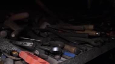 Eski bir fabrika rafında çeşitli aletler, garaj masası - endüstriyel tema. Çeşitli donanım bağlayıcılarının, somunların, cıvataların, anahtarların ve diğer ayrıntıların ve araçların kapatılması