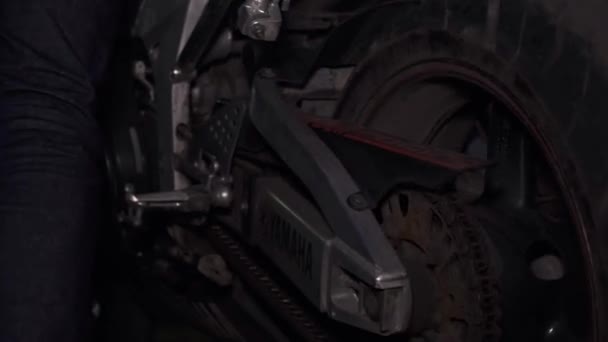 MOSKAU - 9. MÄRZ. Automechaniker bringt abends ein Sportmotorrad zur Reparatur in seine Werkstatt — Stockvideo