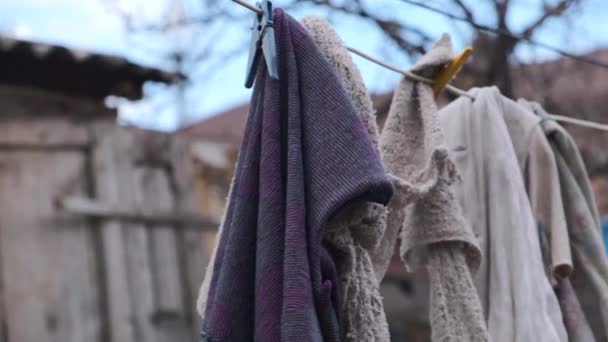 Çamaşırlar kuruması için dışarıda asılı. Çamaşır ipinde kurutma bezi. Çamaşır ipinde asılı kirli paçavralar — Stok video