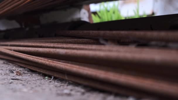 Högen med rostig metallisk armature på marken av byggarbetsplatsen. Närbild av rostiga stålstavar i en bunt. Rustik metall pilspö. Byggnadsbakgrund — Stockvideo