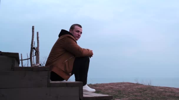 Молодий Кавказький Хлопець Бежевому Верхньому Одязі Чорні Джинси Білі Кросівки — стокове відео