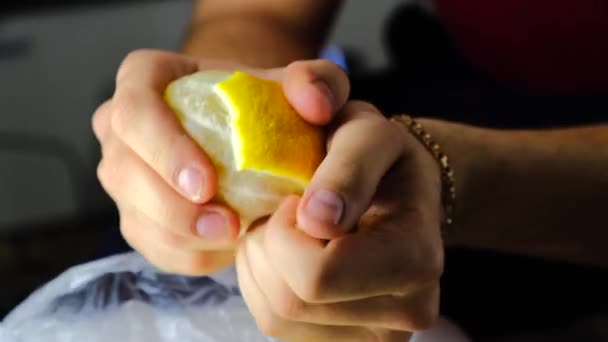 Человек руками чистит желтый лимон. — стоковое видео