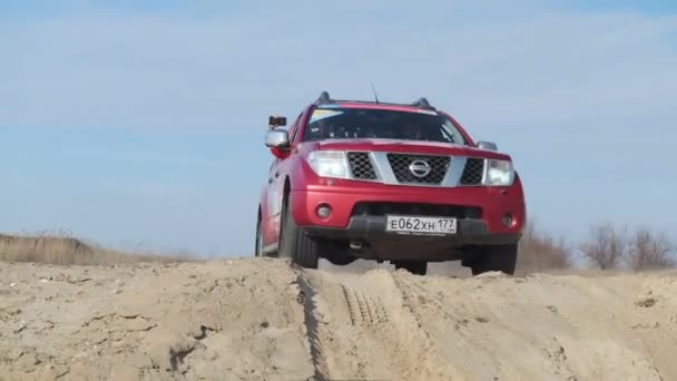 MOSCÚ, RUSIA - 20 de abril. Conducir un coche todoterreno Nissan Navara. Red 4x4 pickup coche a la deriva en el campo. El polvo se dispersa por debajo de las ruedas. Camión pick-up conduce en la arena. El coche desciende de una colina empinada — Vídeo de stock