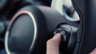 Kestirme yolların, direksiyon ses düğmelerinin yardımıyla hacmin artmasını ve azalmasını kontrol eden bir erkek sürücünün parmağının yakın çekimi. Uzaktan kumandalı ses sistemi olan modern bir araba.