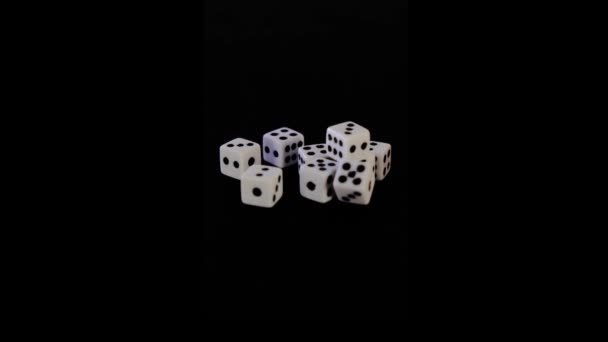 Oyun için siyah arka planda sekiz beyaz zar. Küpler siyah bir yüzeye uzanıyorlar. Görünürde yumuşak bir hareket var. İş ve kumarhane kavramı ya da kumar. Yakın plan.. — Stok video