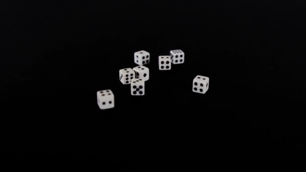 From two sides white cubes fly out on a black background. The dice rotate on a black surface. Stops in sight. Concept of business and casino or gambling. Close-up. — Stock Video