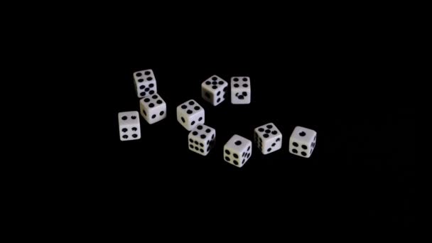 Белые кубики выпадают, вылетают на черном фоне для игры. Кости вращаются на чёрной поверхности. Останавливается. Концепция бизнеса и казино или азартных игр. Крупный план. Медленно, медленно, медленно. — стоковое видео
