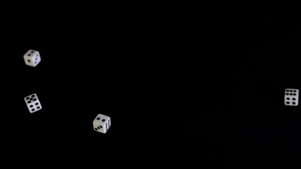 From two sides white cubes fly out on a black background. The dice rotate and bounce on a black surface. Concept of business and casino or gambling. Close-up. Slow mo, slo mo, slow motion — Stock Video