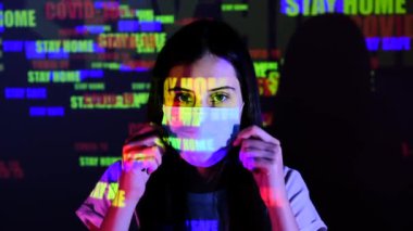 Genç ve güzel bir kız koruyucu tıbbi maske takar ve düzeltir. Duvardaki ve beyaz kadın vücudundaki yansıma yansıması. Sağlık ve güvenlik hayatı kavramı, N1H1 koronavirüs, pandemik.